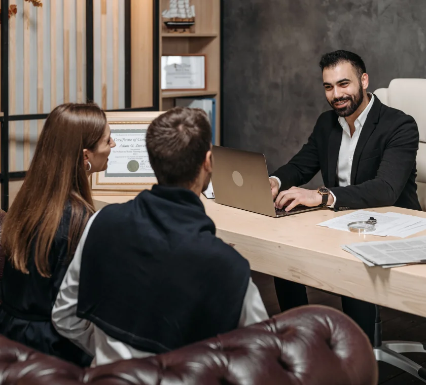 Financial consultant shaking hands with clients after successful loan resolution guidance.